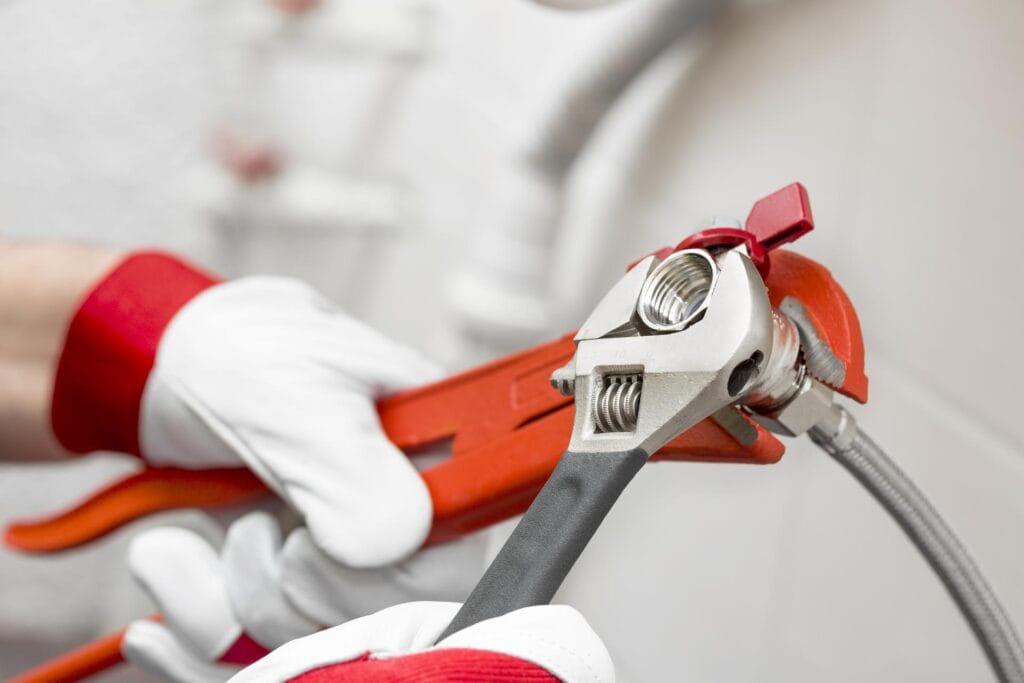 Plumber holding pipe wrenches for an emergency repair in Coconut Creek