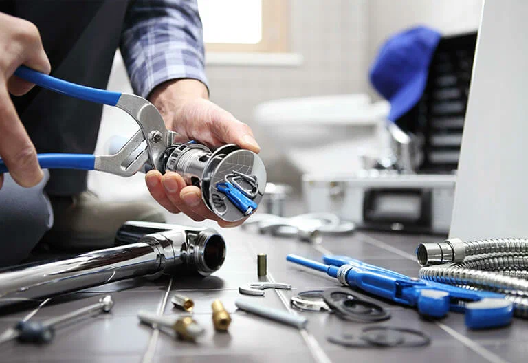 Technician repairing a plumbing fixture with professional tools in Coconut Creek