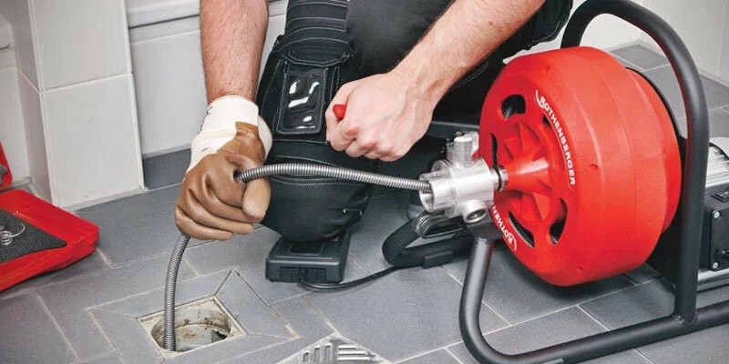 Plumber using a drain-cleaning machine in Coconut Creek