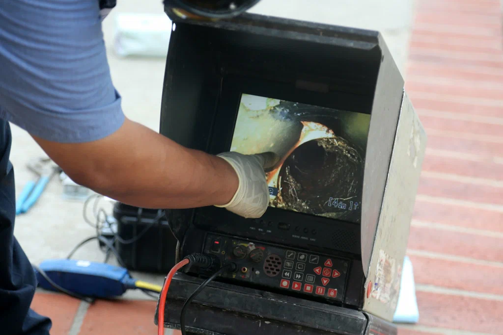 Technician viewing a drain inspection camera in Coconut Creek