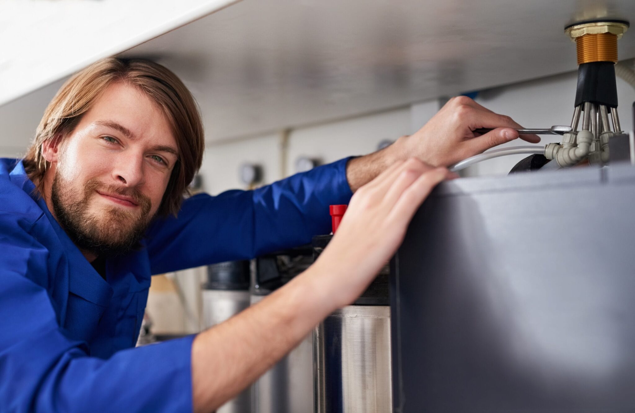 Technician servicing a residential water heater tank in Coconut Creek